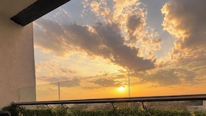 Un balcón con vista a la puesta de sol y nubes.