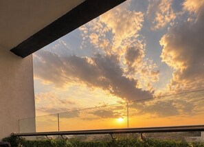A balcony with a view of the sunset and clouds. - Cozy one bedroom Near JKIA | Pool, Gym, SGR & Easy Expressway Access (Nairobi)