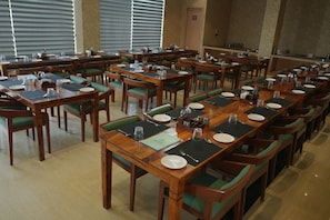 Un amplio comedor con numerosas mesas y sillas dispuestas en filas.
