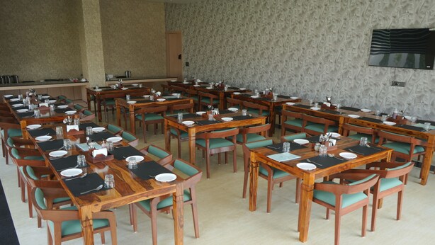 A conference room with long tables and chairs, equipped with nameplates and water glasses.