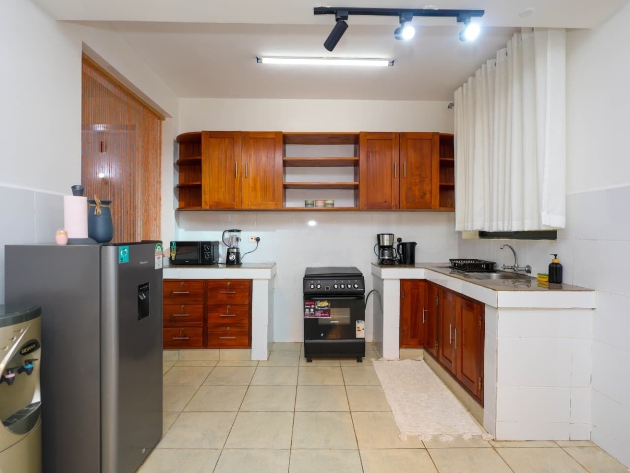 Una cocina compacta con refrigerador, horno, microondas y gabinetes de madera.