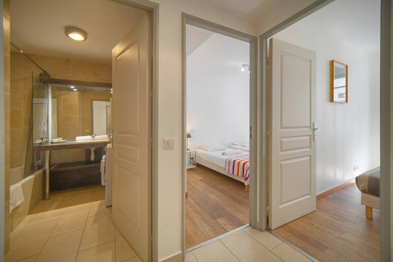 Habitació d'hotel amb bany, un llit i un terra de fusta.