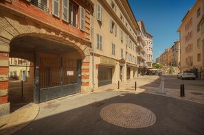 Eine Straße mit einem Backsteinbogen, einem verschlossenen Tor und Gebäuden mit Balkonen.
