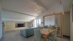 A modern living room with a dining area, a sofa, and a TV. - FRGK - SUQUET DUPLEX WITH VIEWS OF THE HARBOR AND THE PALACE - 2BR (Cannes)