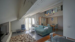 A modern living space with a sofa, dining table, and kitchen area. - FRGK - SUQUET DUPLEX WITH VIEWS OF THE HARBOR AND THE PALACE - 2BR (Cannes)