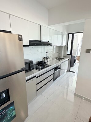A modern kitchen with stainless steel appliances, white cabinetry, and a tiled backsplash. - Spacious 2BR Westlands (Nairobi)