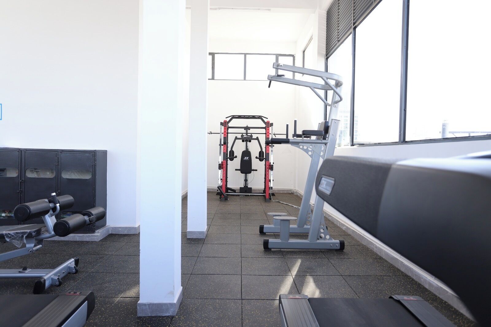 A gym with treadmills, weight machines, and a squat rack.