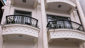 A multi-story building with balconies, large windows, and a white facade. - Hoanglee Villa (Mang Yang)