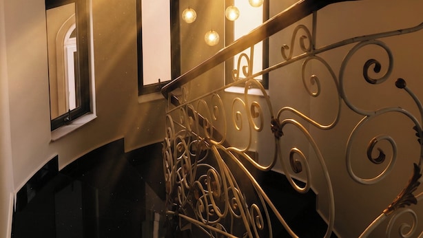 A staircase with a metal railing and hanging light fixtures. - Hoanglee Villa (Mang Yang)