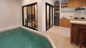 Una cocina moderna con armarios de madera, horno empotrado y refrigerador de acero inoxidable.