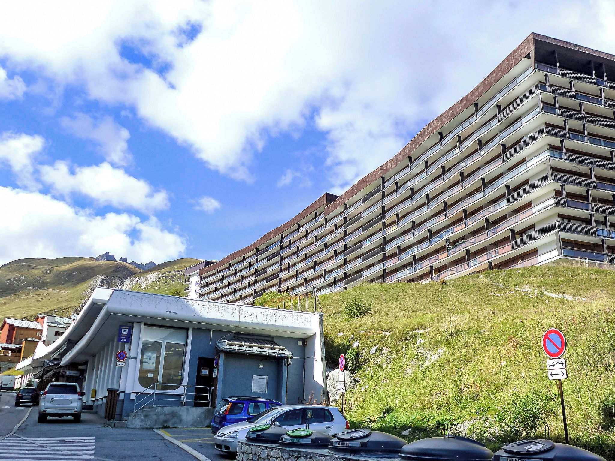 Un parking à étages, situé à côté d’un bâtiment doté d’un toit en pente.