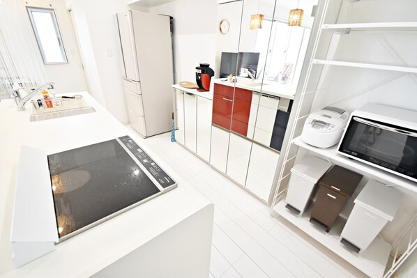 A modern kitchen with a built-in stove, a coffee machine, and a microwave.