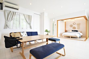 Habitación de hotel moderna con comedor, una cama y vistas al exterior.