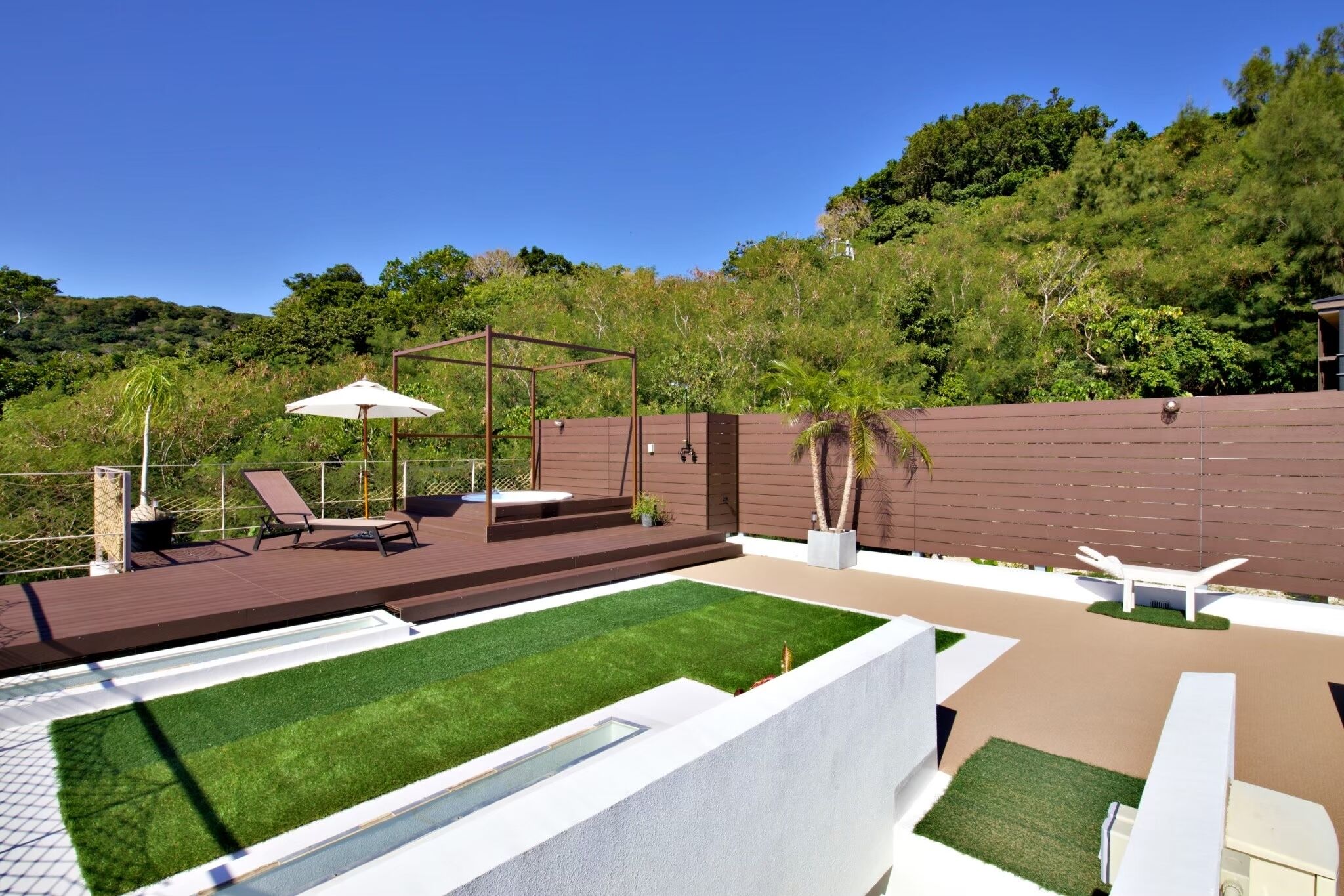 Une terrasse extérieure moderne avec une piscine, des chaises longues et une pergola.