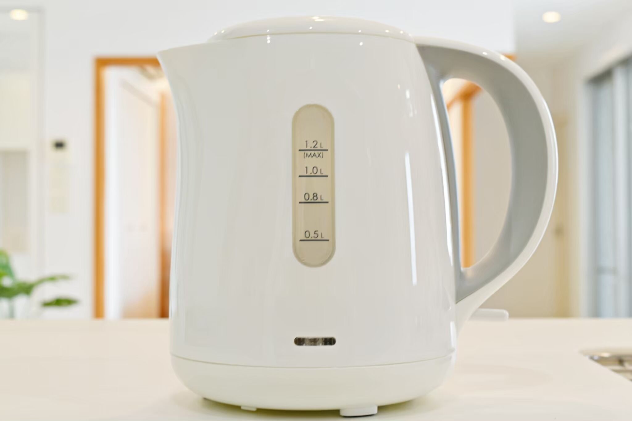 Un bollitore elettrico bianco con indicatori di livello esterni.