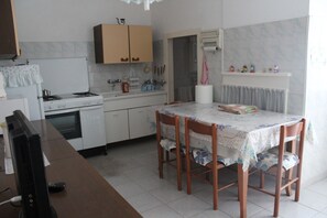 Cucina con forno, piano cottura e tavolo da pranzo con sedie.