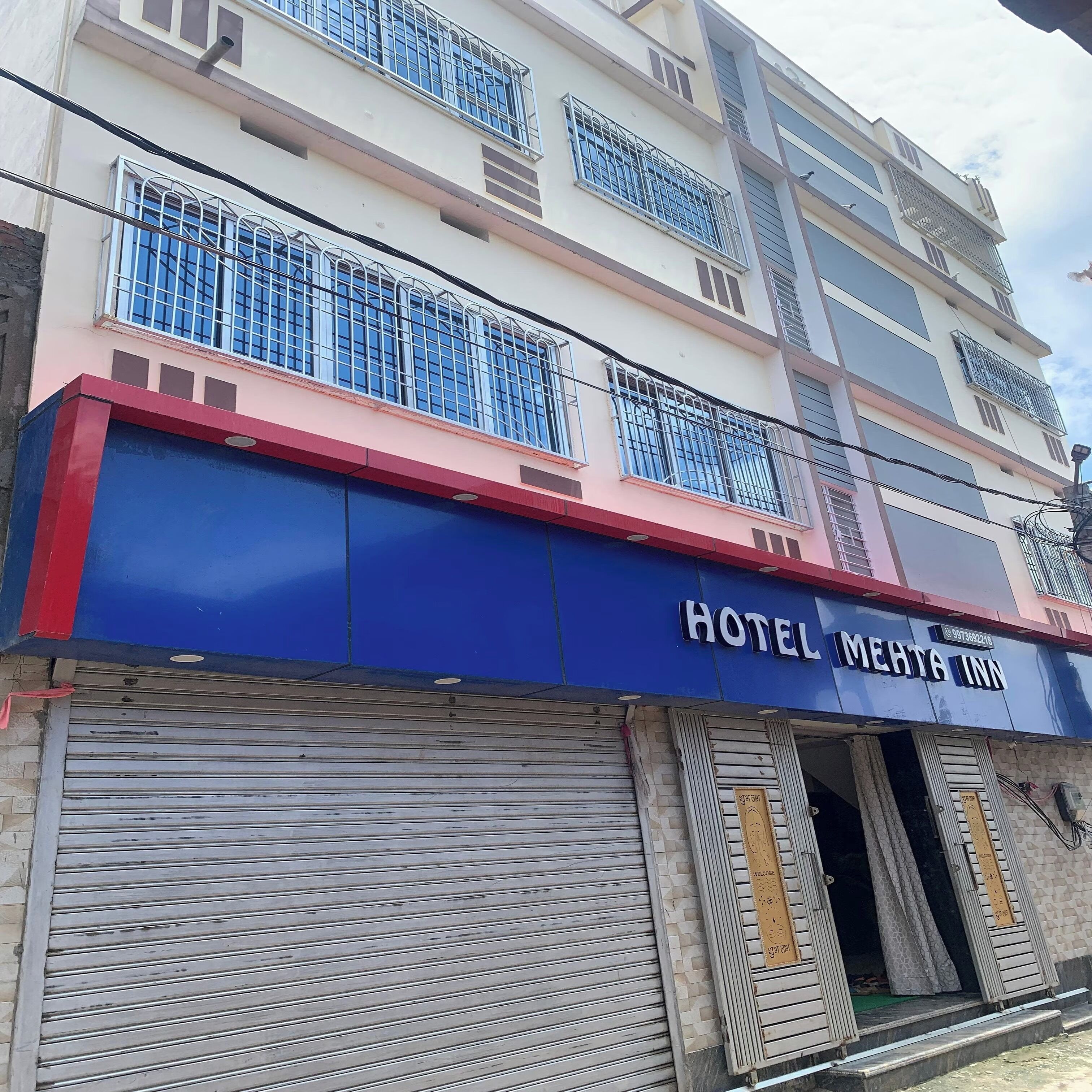 A building with a blue facade and a sign reading 'HOTEL MEHTA INN'.