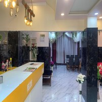 A reception area with a marble floor, a reception desk, and a dining area with a table and chairs.