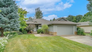 A residential house with a front lawn, a garage, and a driveway.