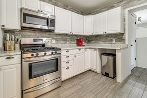 A modern kitchen with white cabinets, stainless steel appliances, and a granite countertop. - 4 Mi to UToledo! Cozy Family Home (Toledo)