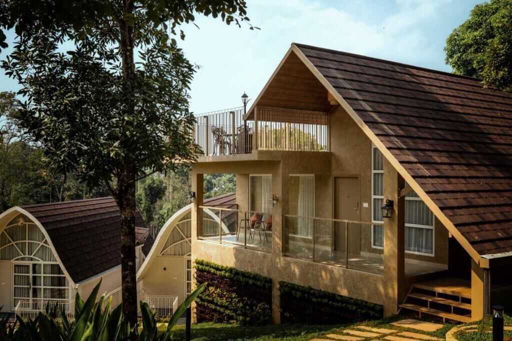 Una casa moderna con balcón, ventanas amplias y techo inclinado.