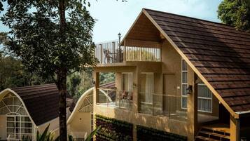 Una casa moderna con balcón, ventanas amplias y techo inclinado.