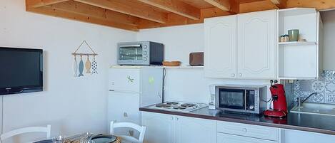 A compact kitchen with white cabinets, a microwave, a toaster, and a coffee maker.