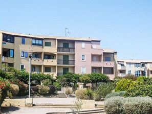 A multi-story residential building with balconies, a clear sky, and surrounding greenery. - Les Terrasses de la Méditerranée by Interhome (Saint Pierre La Mer)