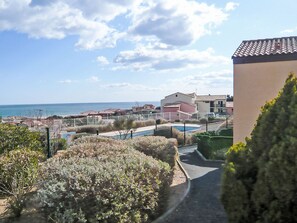 A coastal residential area with houses, a swimming pool, and a clear view of the sea. - Les Terrasses de la Méditerranée by Interhome (Saint Pierre La Mer)