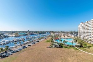 Una marina con barche, una piscina e un hotel con numerosi balconi.