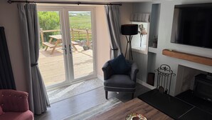 Una sala de estar con sofá, sillón, mesa de centro y chimenea.