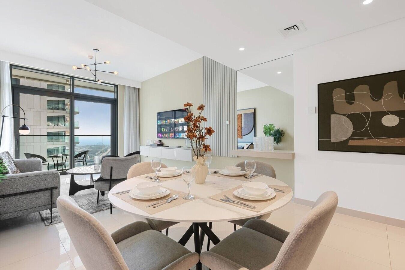 A modern dining area with a round table set for four, a large window with a city view, and a minimalist decor.