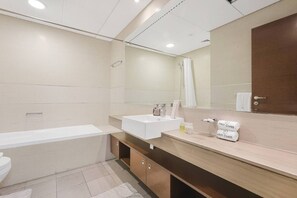 Een moderne badkamer met een bad, een wastafel en een douche.