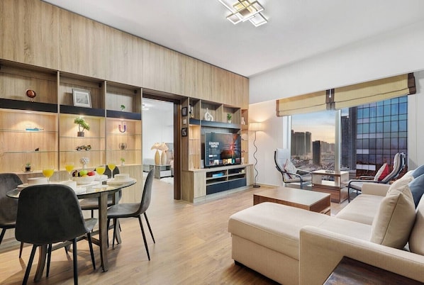Een moderne woonkamer met een bank, eettafel, stoelen en een televisie.