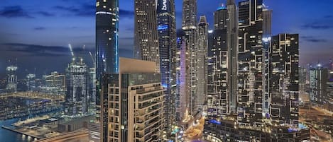 A cityscape with high-rise buildings, a marina, and a bridge.