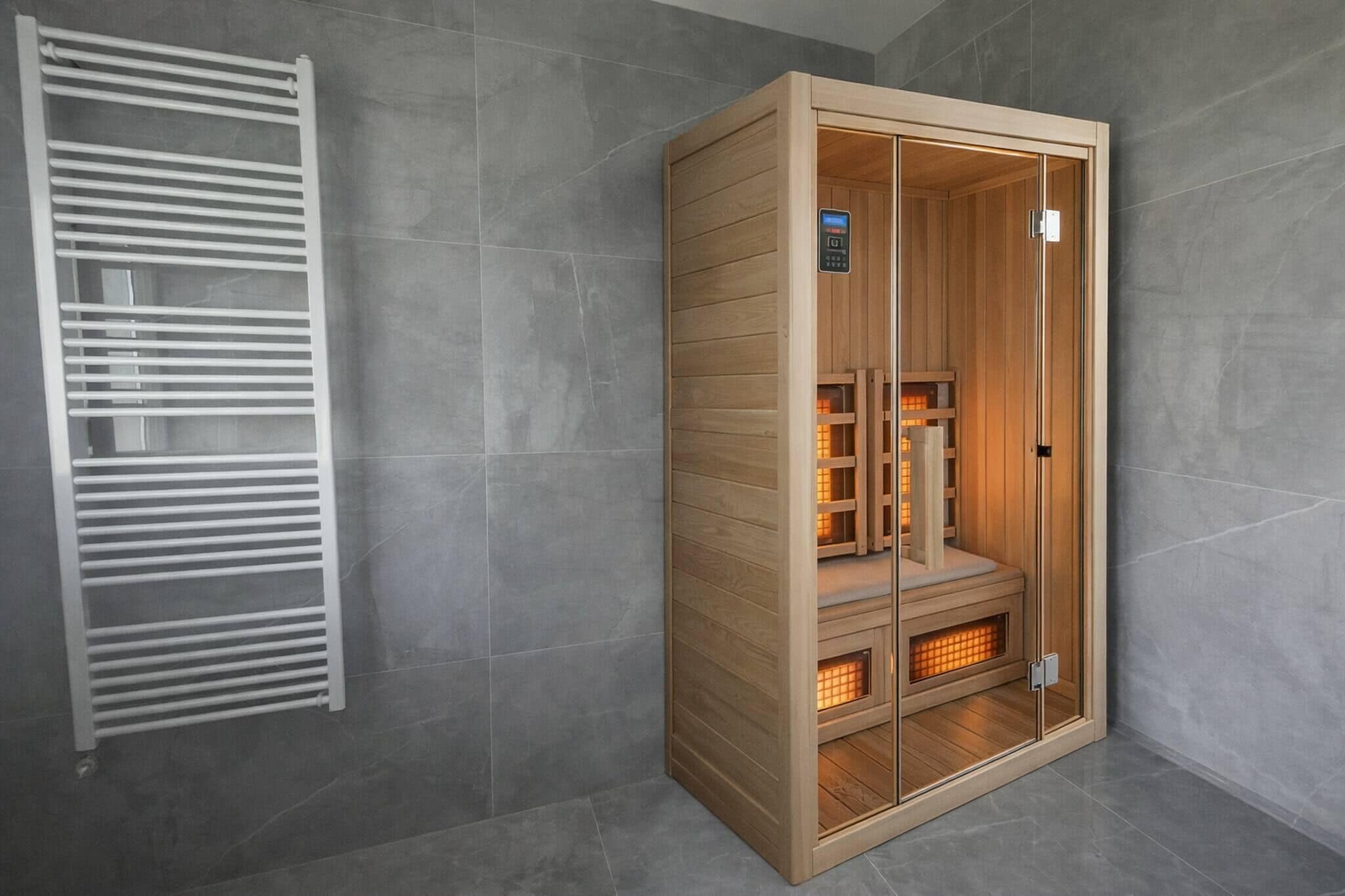 Uma sauna com painel de controle, bancos de madeira e porta de vidro.