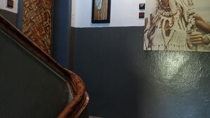 Un pasillo con una puerta estampada, una obra de arte enmarco y un póster grande en la pared.