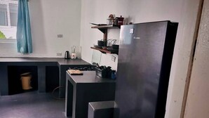 Eine kleine Küche mit Kühlschrank, Herd und einer Arbeitsplatte.