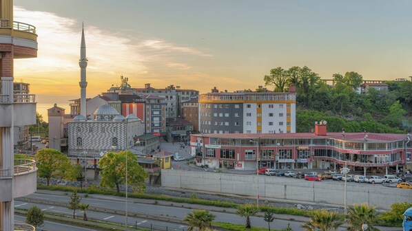 A cityscape with a prominent mosque, a modern building, and a mix of residential and commercial structures.