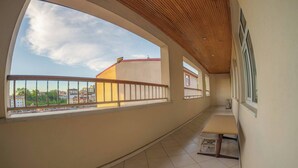 A corridor with a wooden ceiling, large windows, and a view of buildings. - Spacious Hopa Suite & City View (Hopa)