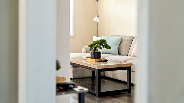 Una sala de estar moderna con un sofá, una mesa de centro y una lámpara de pie.