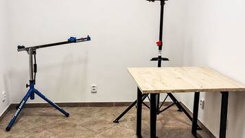 Una habitación con un trípode, una mesa y un dispositivo fijado a la pared.