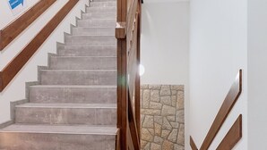 A staircase with wooden handrails and a stone wall at the bottom. - Apartment Arnika by Interhome (Janov nad Nisou)