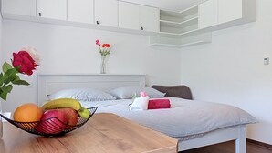 A compact bedroom with a bed, bedside table, and a small window. - Apartment Arnika by Interhome (Janov nad Nisou)