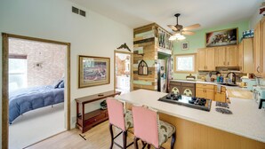 A compact kitchen with a central island, wooden cabinets, and a dining area with chairs. - Peaceful Farm Stay Near Cuyahoga Valley NP (Cuyahoga Falls)
