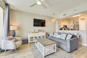 Ein modernes Wohnzimmer mit einem grauen Sofa, einem Couchtisch und einem Fernseher.