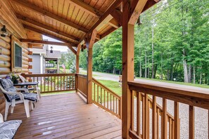A wooden deck with chairs and a table, overlooking a forested area. - Great for Elk Viewing! Creekside Maggie Valley Gem (Maggie Valley)