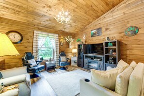 A wooden interior with a sofa, armchair, television, fireplace, and a clock. - Great for Elk Viewing! Creekside Maggie Valley Gem (Maggie Valley)