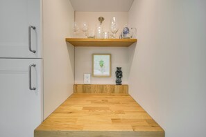 A kitchen with a wooden countertop, a shelf with glassware, a framed picture, and a small statue. - 2 Mi to UNC Campus! Quiet Escape w/ Deck & Grill (Carrboro)