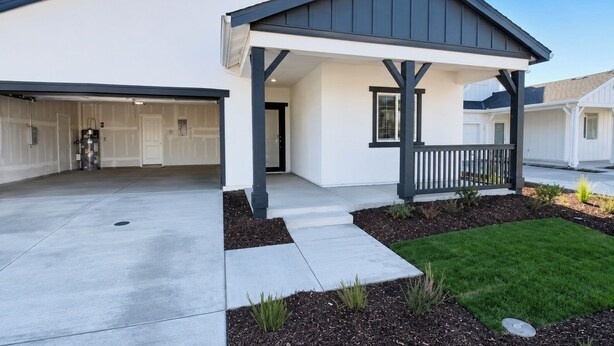 Une maison moderne à deux étages, dotée d’un porche abrité, d’un garage et d’une pelouse bien entretenue.